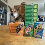 Alameda Post - Mouf the dog sits behind stacks of Girlscout cookies.