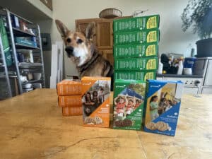 Alameda Post - Mouf the dog sits behind stacks of Girlscout cookies.