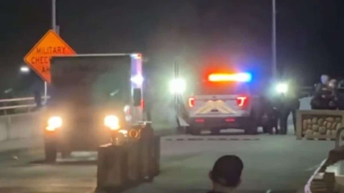Alameda Post - A blurry night time photo of a Uhaul backing towards a police vehicle on a bridge. 