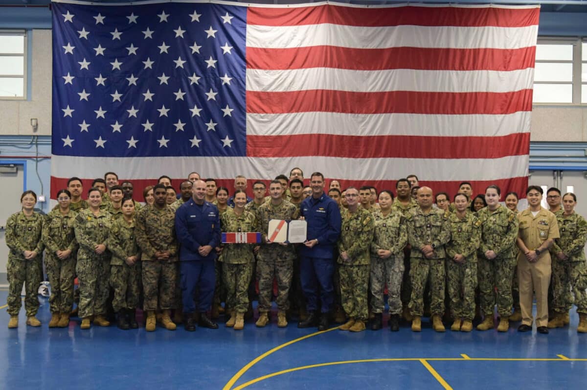 Alameda Post - A group photo of sailors and marines in front of an American flag. 