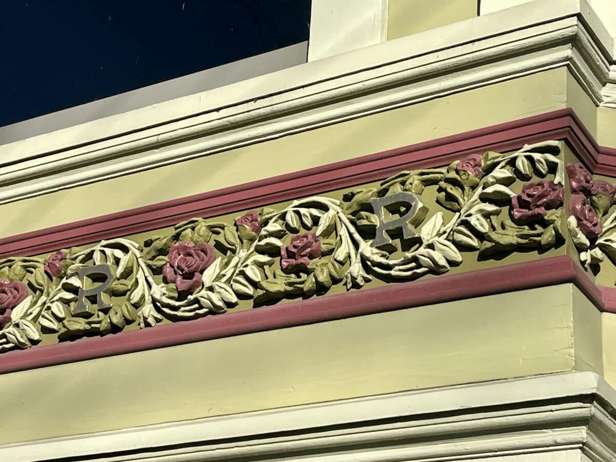 Alameda Post - An ornate plaster cast on the outside of a home with vines, roses, and the letter R.