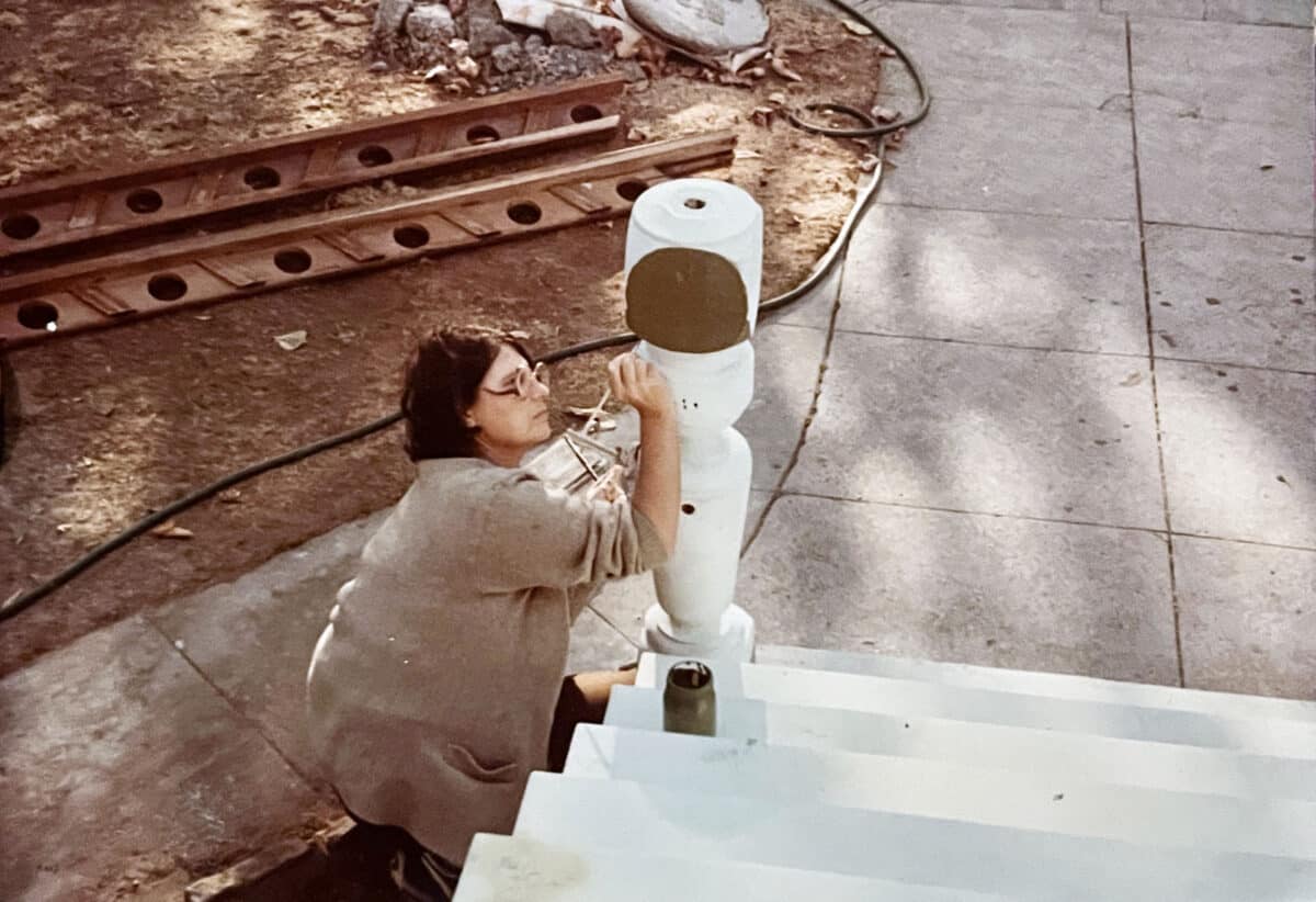 Alameda Post - an old photo of a woman painting a post on an outdoor staircase. .