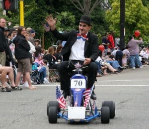 Alameda Post - Mark Betz rides in the Alameda Fourth of July parade dressed as Charlie Chaplin.