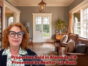 Alameda Post - A red haired woman smiles the living room of a home for sale.