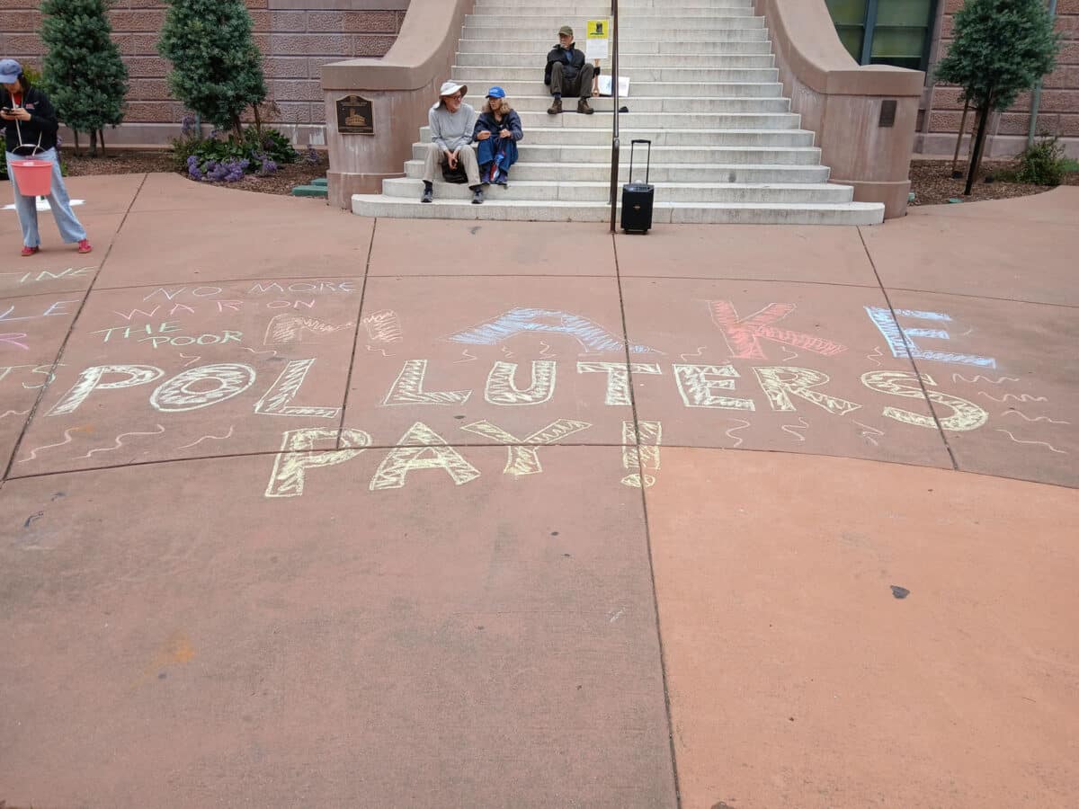 Alameda Post - Sidewalk chalk in front of City hall that says "Make polluters pay."