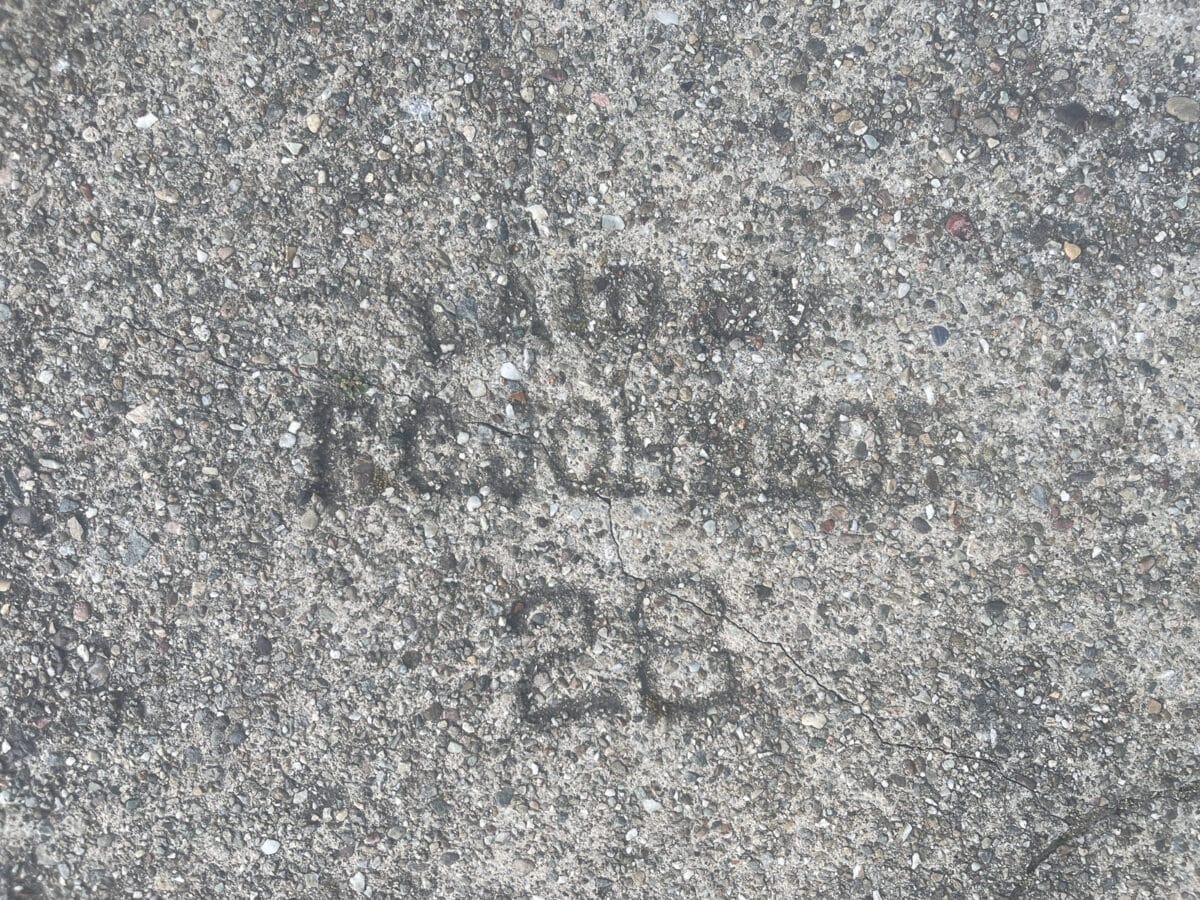 Alameda Post - A stamped sidewalk brand with the number 28.