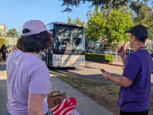 Alameda Post - Two adults dressed in purple in Paden’s Safe Haven and Resource Committee look at the area in front of Paden Elementary.