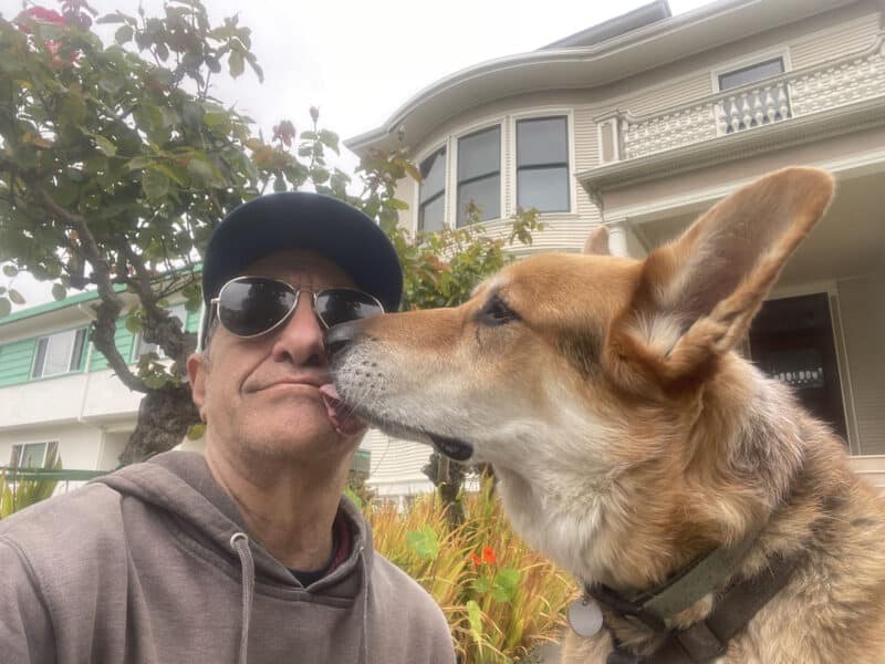 Alameda Post - Mouf the dog kisses his human companion, Jeff.