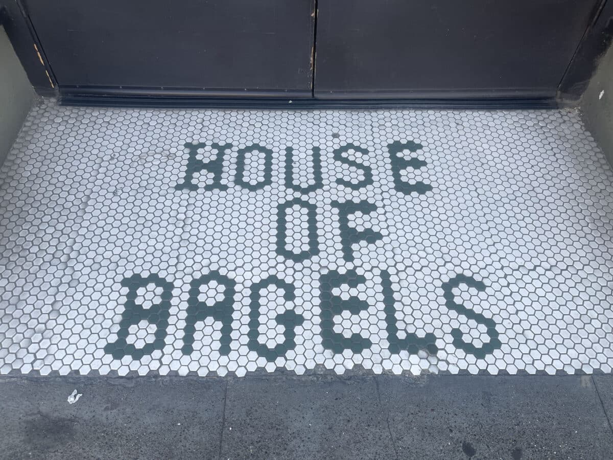 Alameda Post - A mosaic of small black and white tiles that says House of Bagels. 