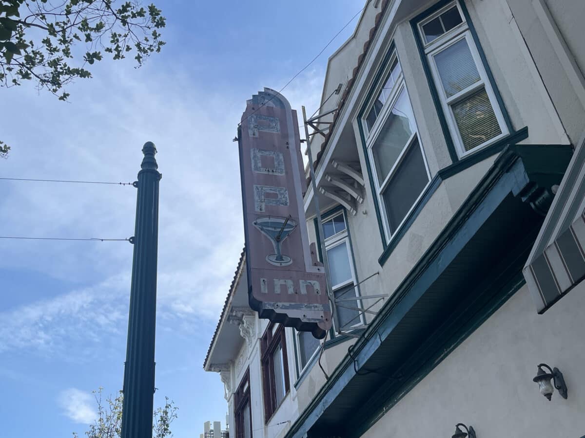 Alameda Post An old neon sign during the daytime. It says Pop Inn and has a martini glass. 