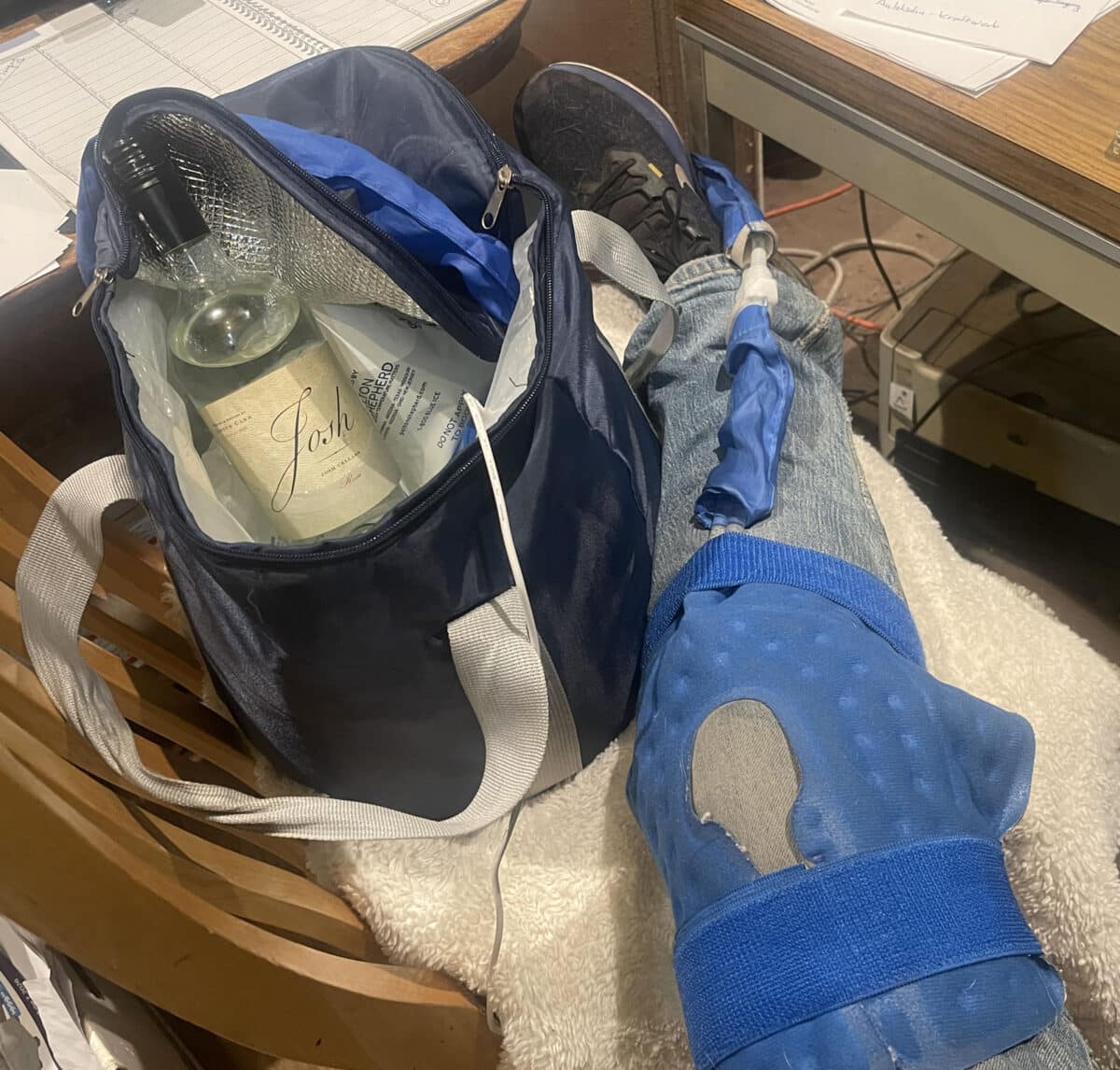 Alameda Post - A photo of a leg in a circulating ice wrap, and a bottle of wine chilling with ice.