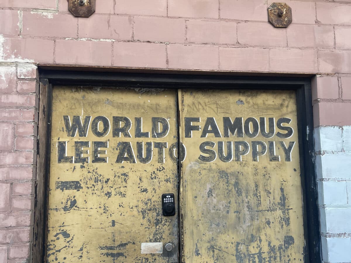 Alameda Post - Old, large metal doors with the text "World Famous Lee Auto Supply."