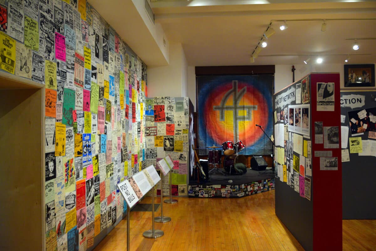Alameda Post - A museum exhibit full of punk rock posters, memorabilia, and a drum kit.