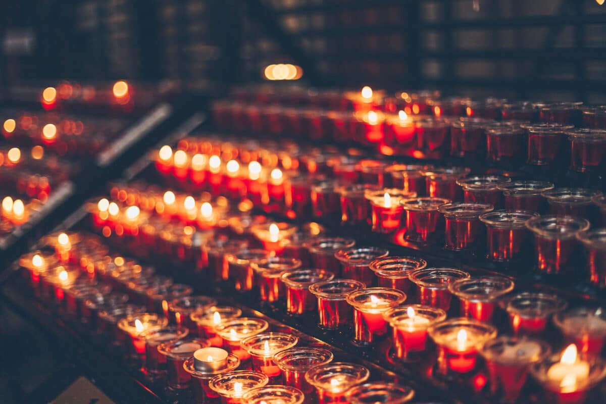 Alameda Post - rows of lit and unlit prayer candles.