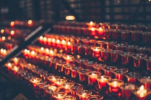Alameda Post - rows of lit and unlit prayer candles.
