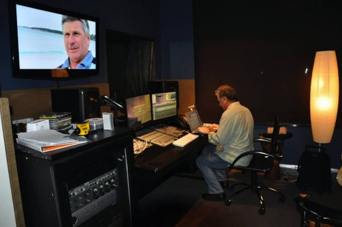 Alameda Post - A man sits at a large editing booth and works. 
