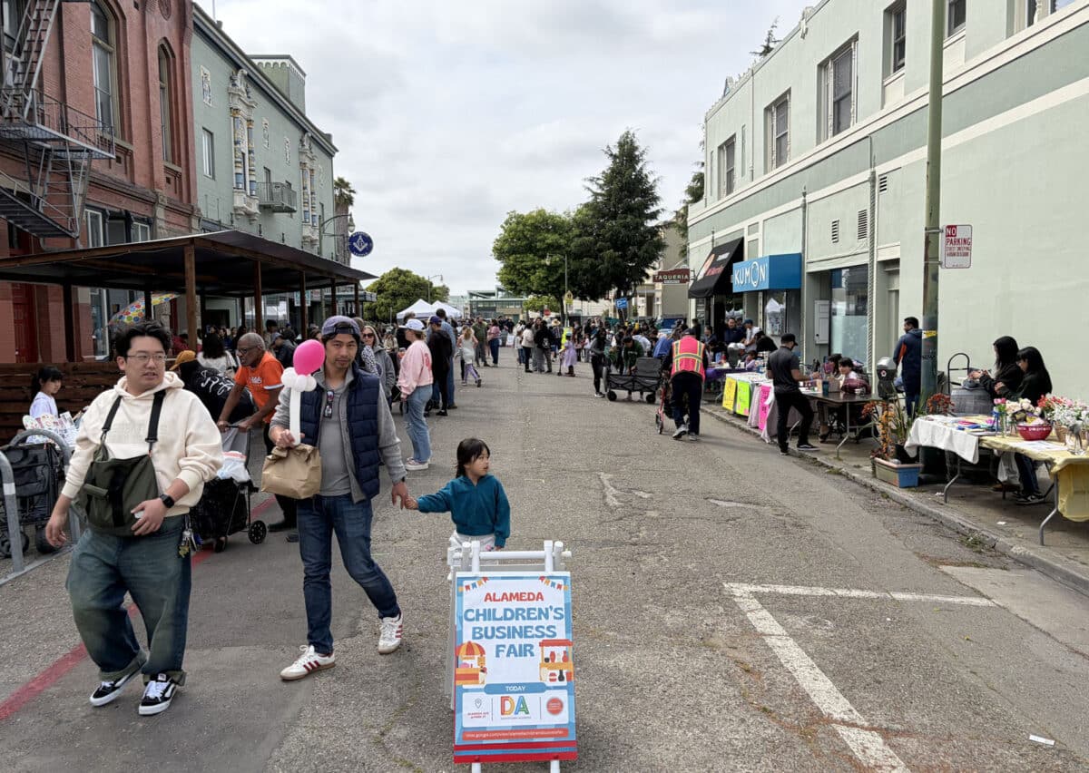Alameda Post - People mill around booths on Alameda Avenue at the Children's Business Fair.