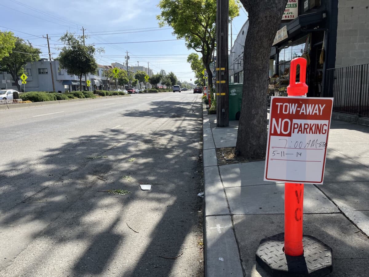 Alameda Post - An orange cone on a sidewalk with a sign that says "Tow Away. No Parking."