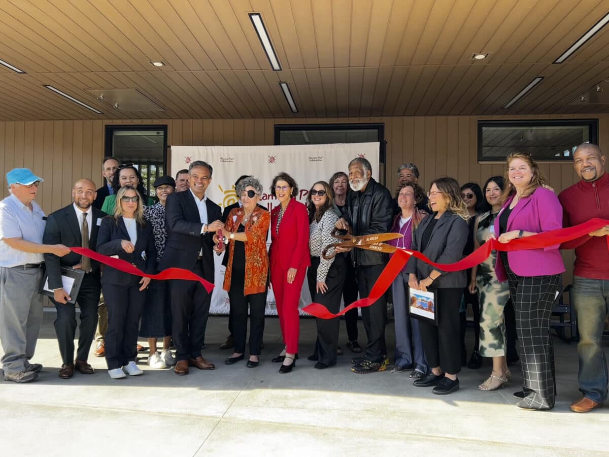 Alameda Post - A crowd of people gather to cut a ribbon.