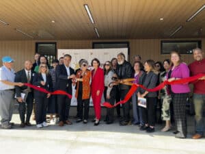Alameda Post - A crowd of people gather to cut a ribbon.