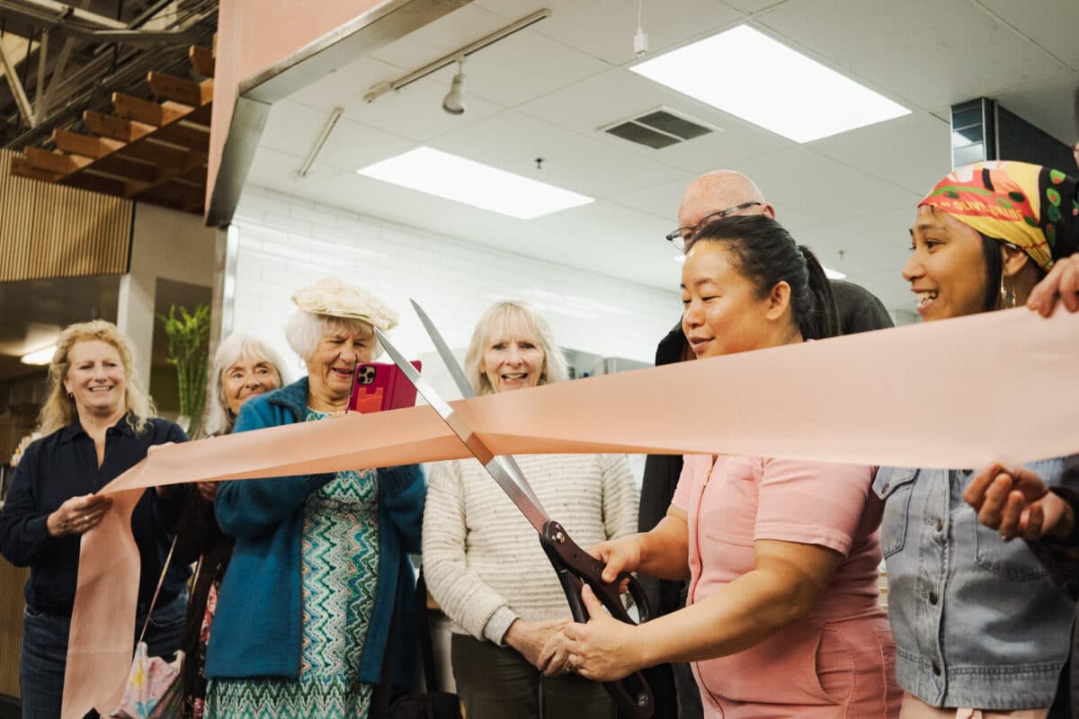 A baker cuts a ribbon to open her new bakery.