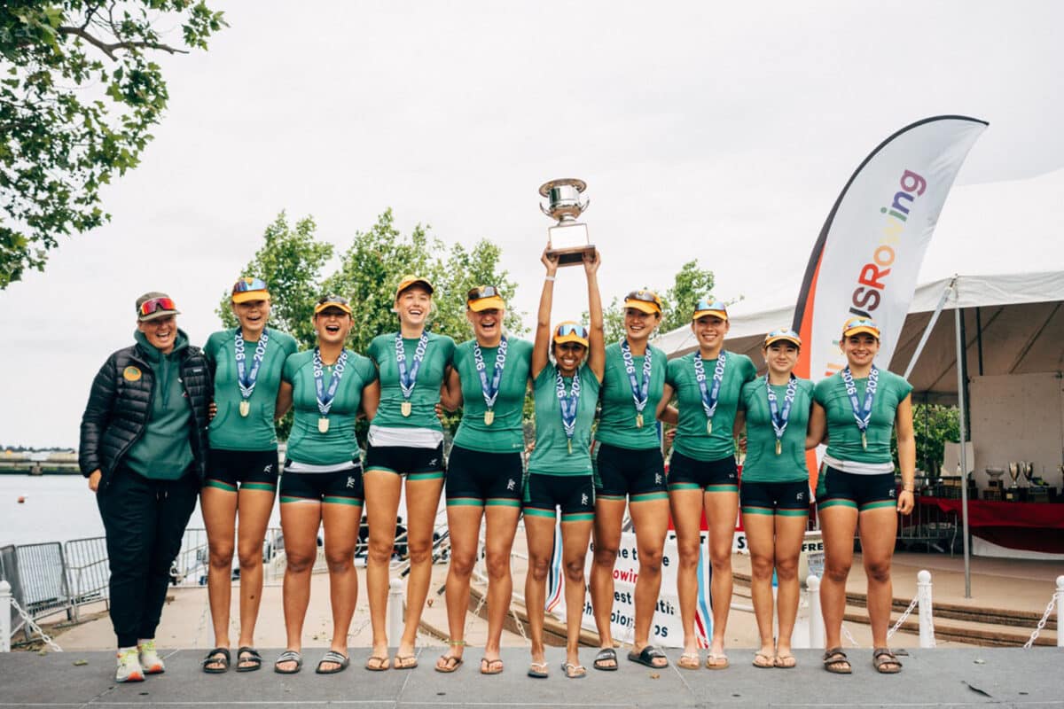 Alameda Post - A women's rowing team poses together and one rower lifts a trophy.
