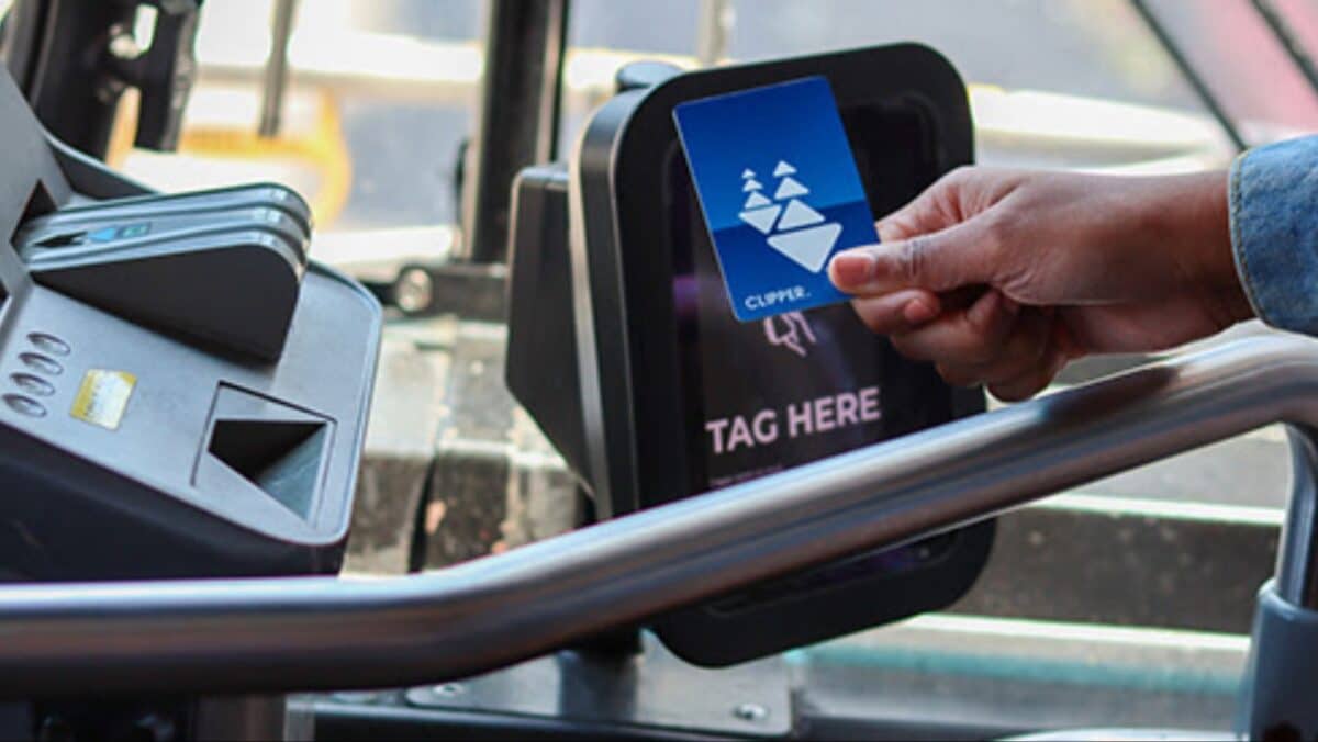 Alameda Post - A hand waves a clipper card over a card reader on a AC Transit bus.