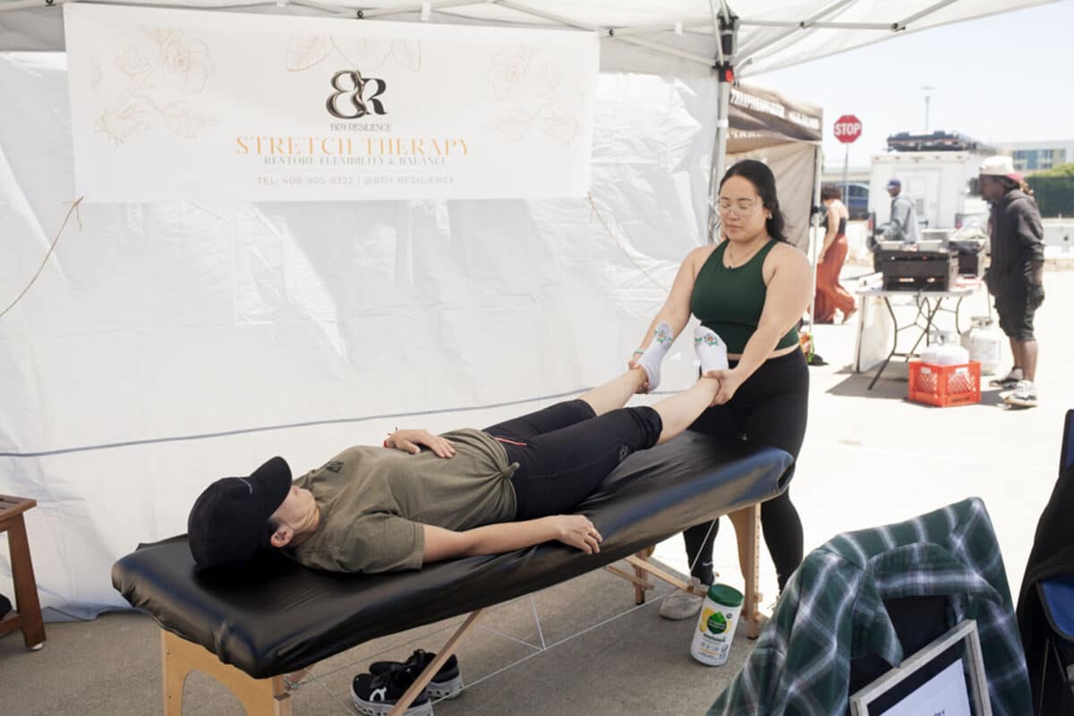Alameda Post - A stretch therapist stretches a patient on a massage table.