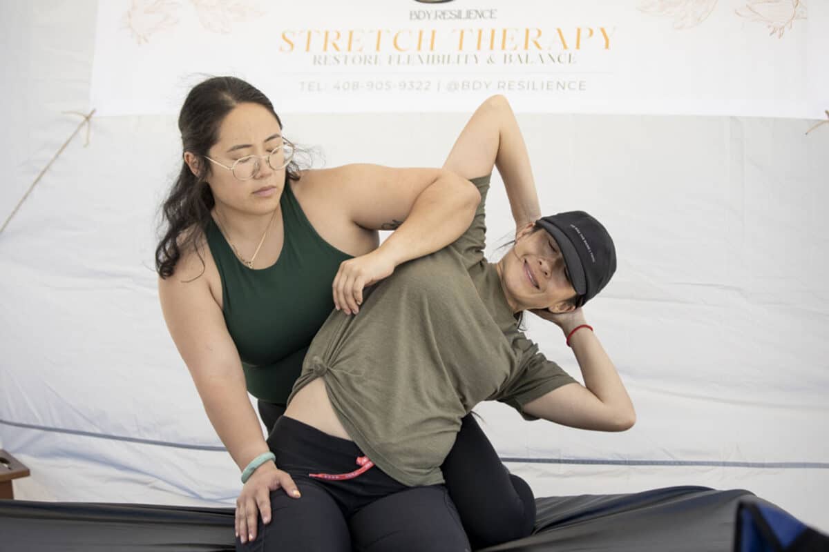 Alameda Post - A stretch therapist stretches a patient on a massage table.