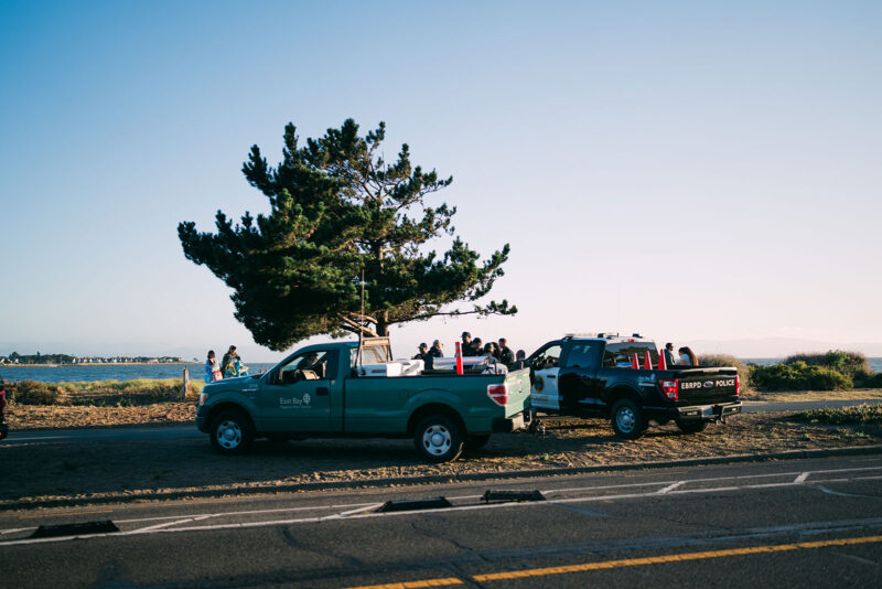Alameda Post - Two East Bay Regional Parks District vehicles parked on the beach next to police officers.