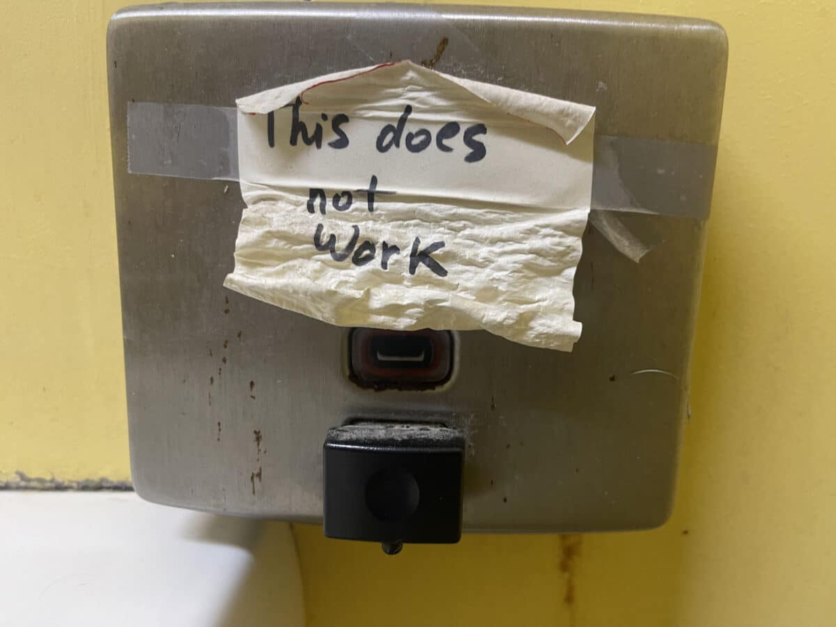 Alameda Post - An old metal liquid soap dispenser with a note taped on it that says "This does not work."