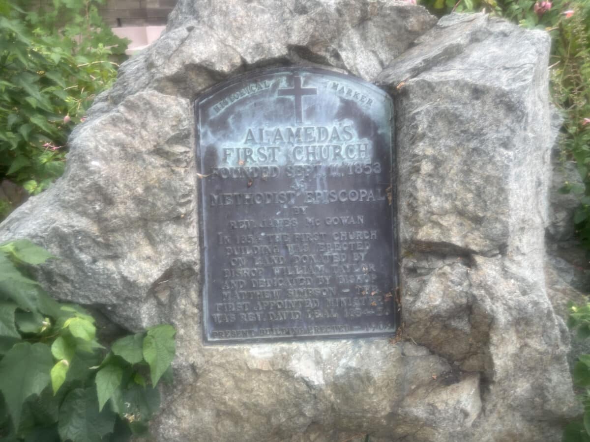 Alameda Post - A metal plaque in a stone that says "Alameda's first church. 1853." with more harder to read details. 