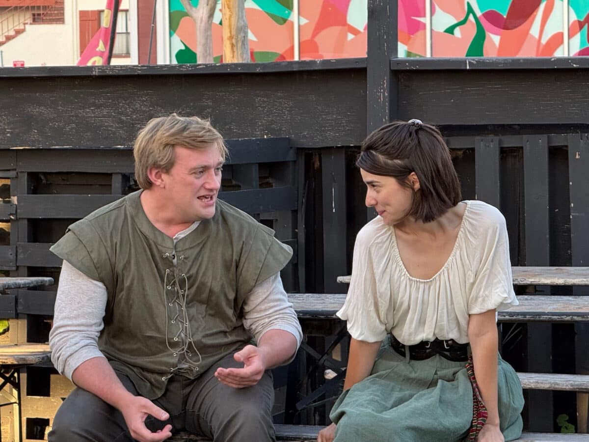 Alameda Post - A young man and woman sit on a picnic bench and animatedly talk together. 