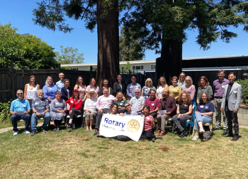 Alameda Post - A large group photo of people outdoors. In the middle, people hold a sign for the Rotary Club of Alameda.