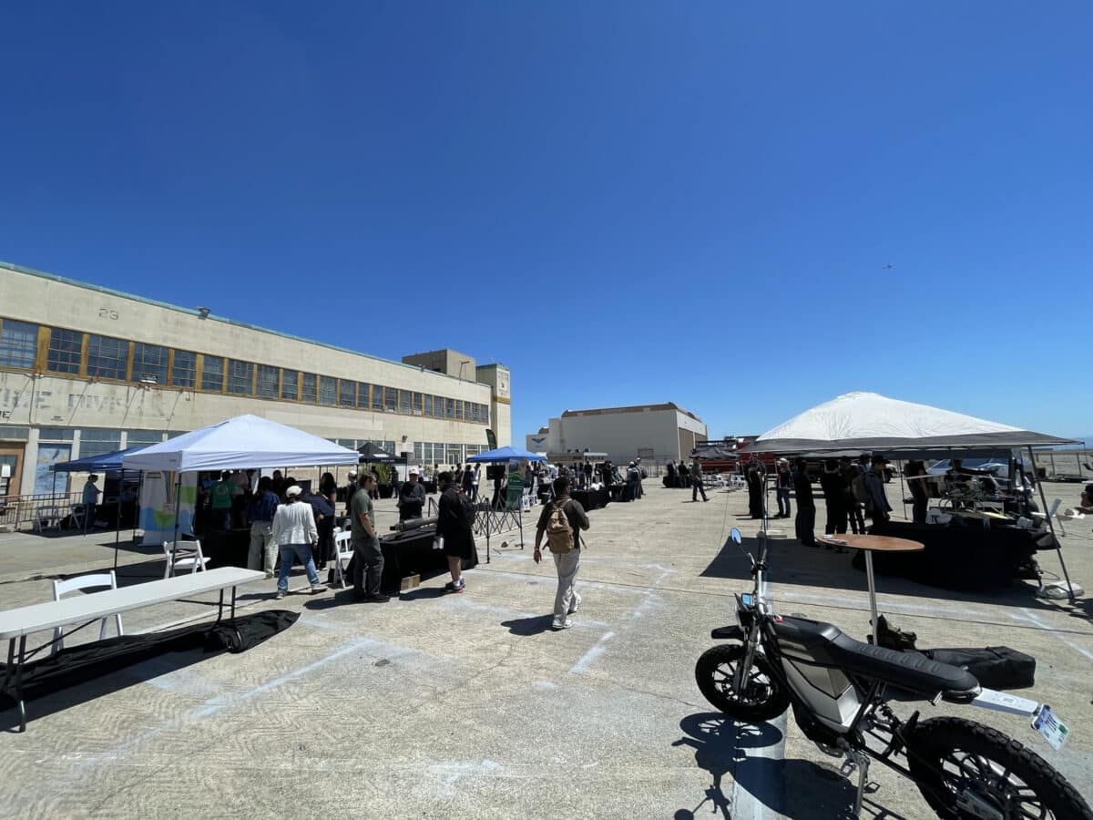 Alameda Post - A gathering at Alameda Point with attendees talking with people at booths. 