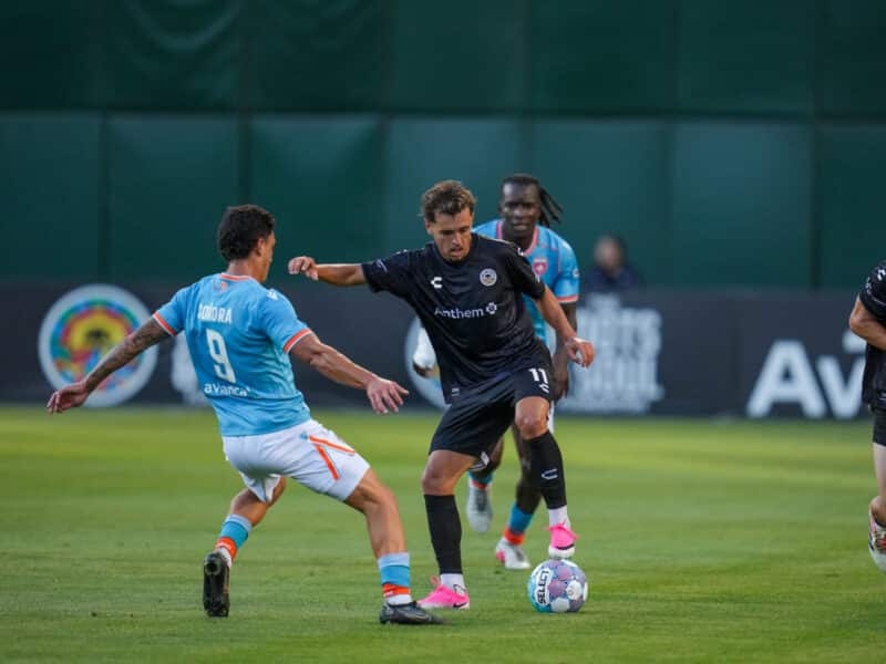 Alameda Post - An Oakland Roots player tries to keep the ball in possession Miami. against
