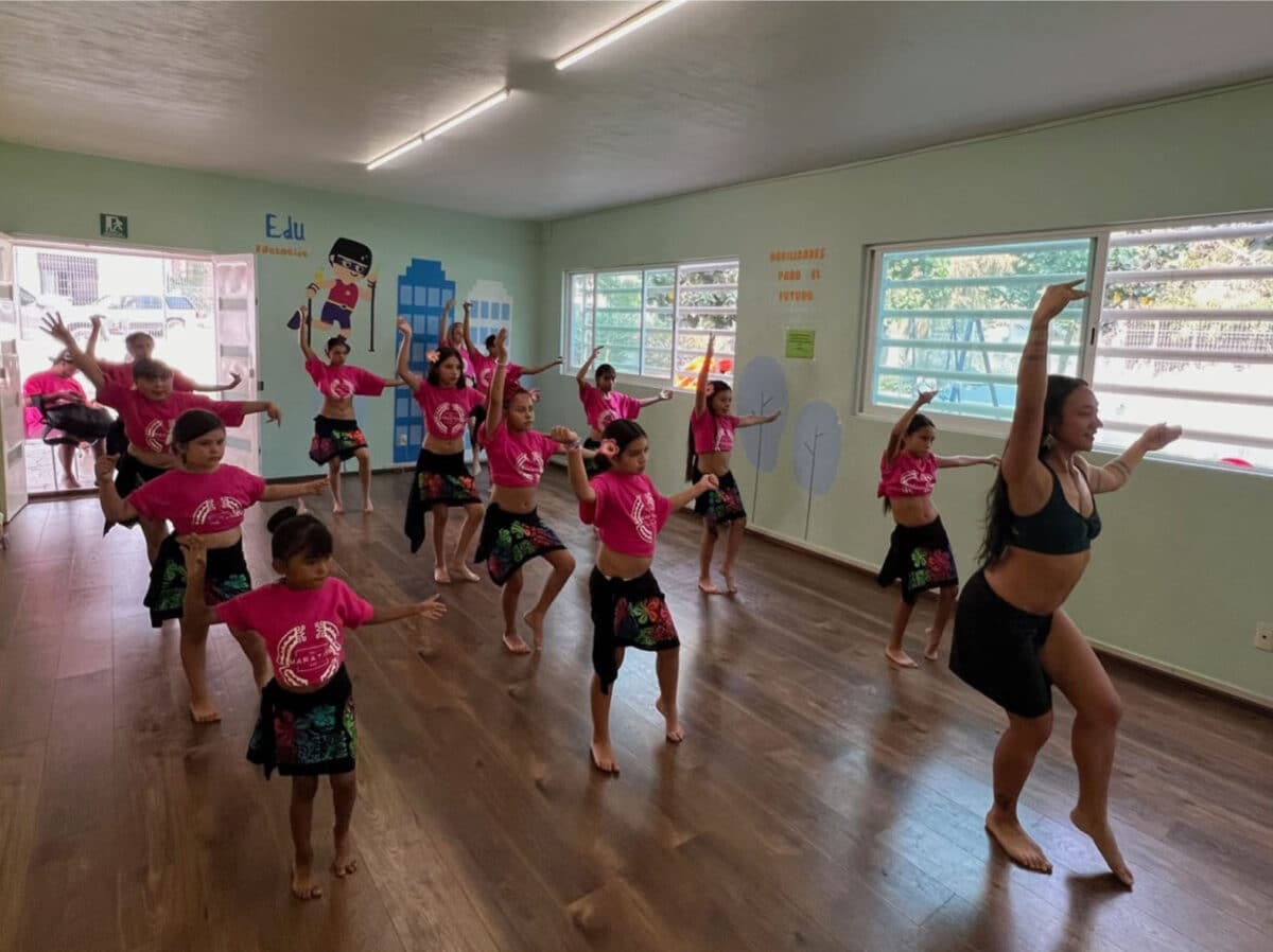Alameda Post - A classroom of children follow a woman as she leads them in dance class.