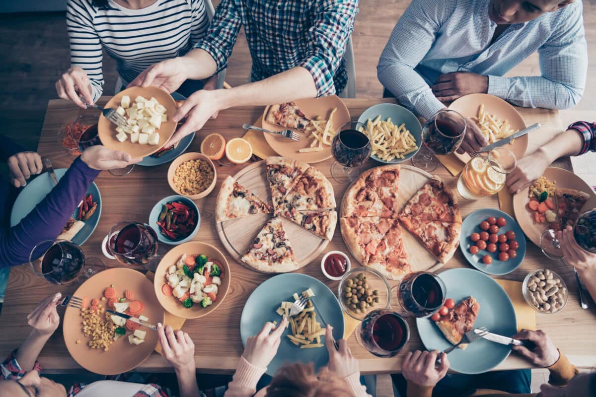 Alameda Post - A group of people sit around a table at a restaurant and share food and drinks.