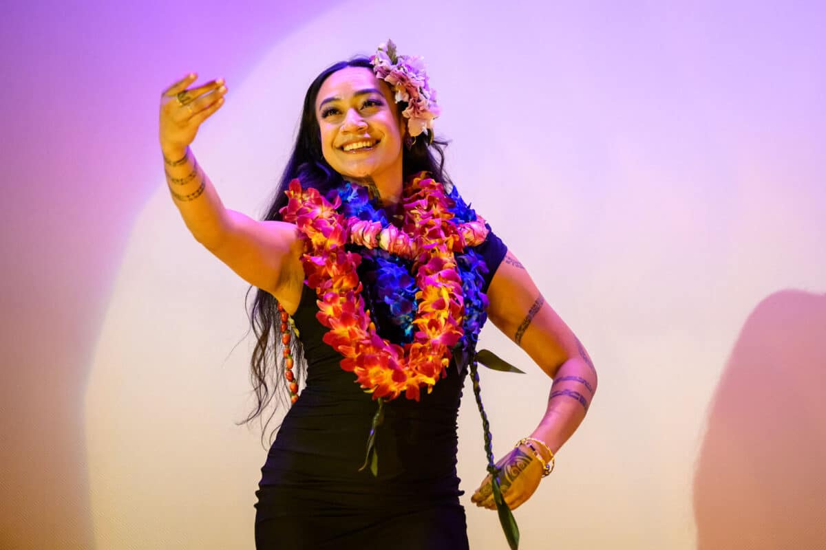 Alameda Post - Makana wears leis and flowers and dances while smiling onstage. 