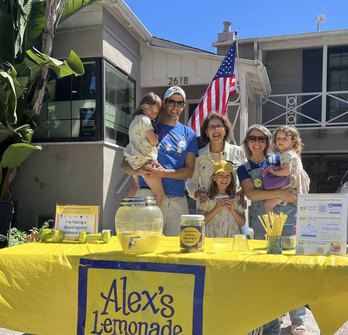 Alameda Post - A family with three young girls stands behind a lemonade stand with Mayor Ascraft.
