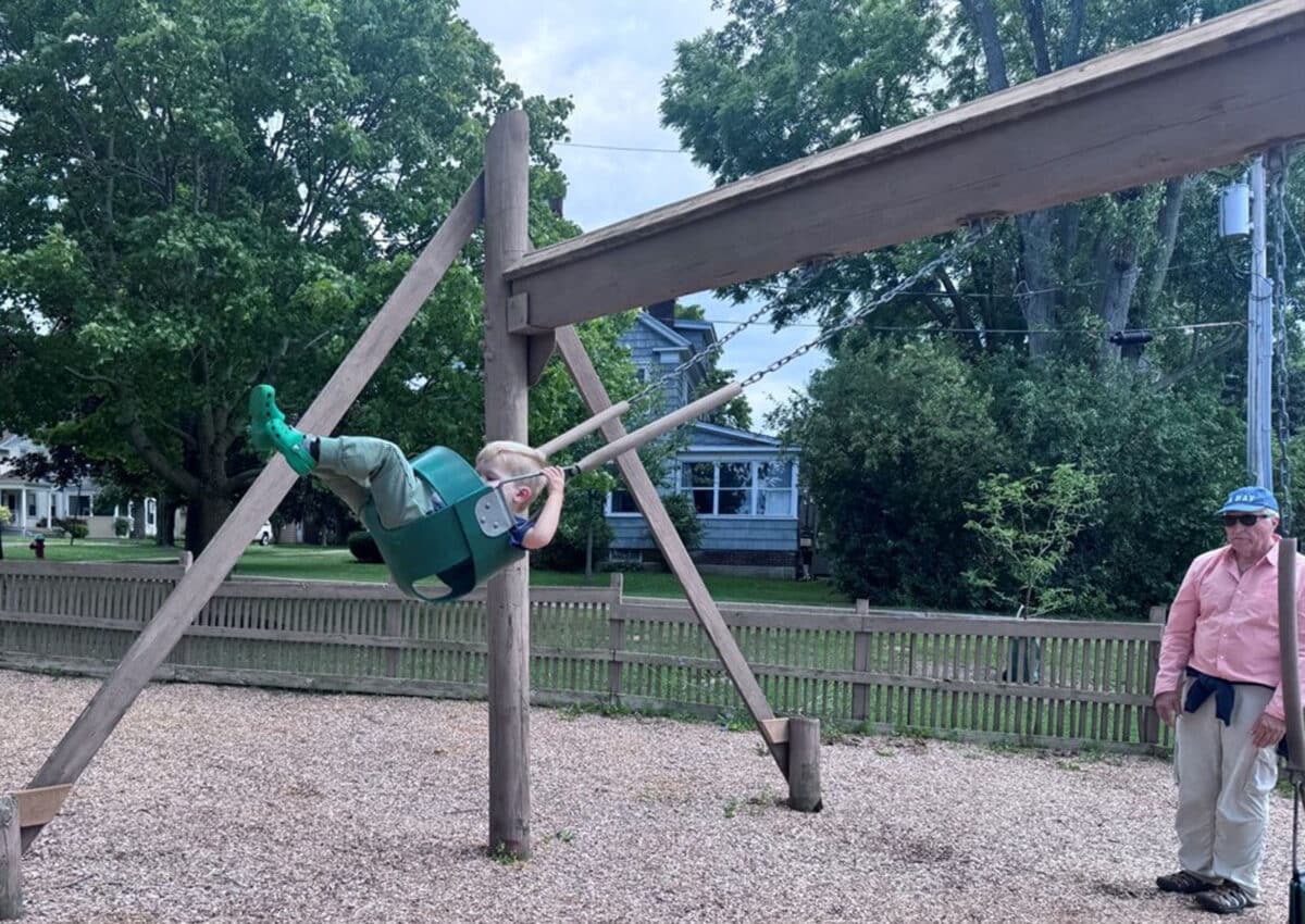 Alameda Post - A photo of a child playing on a swingset.
