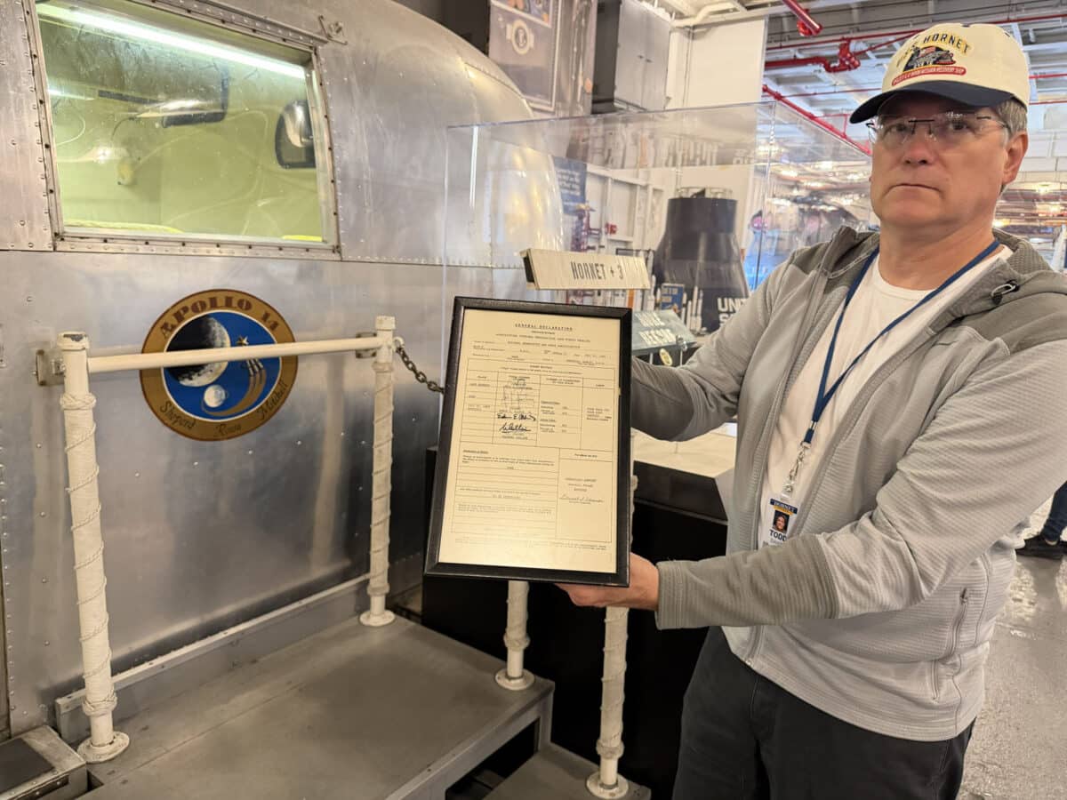 Alameda Post - A volunteer at the U.S.S. Hornet museum holds a piece of paper.