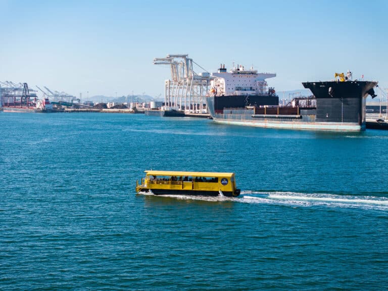 Alameda Post - aerial view of a yellow ferry boat in front of large tankers