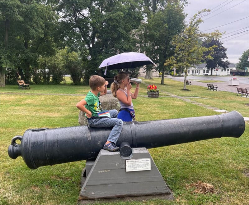 Alameda Post - Two young children sit on and stand next to a cannon.