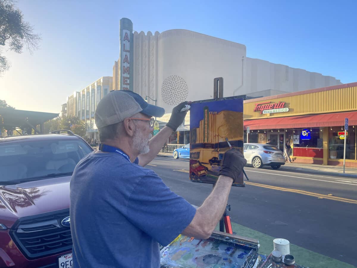Alameda Post - A painter outside of the historic Alameda theater paints in the beautiful day.