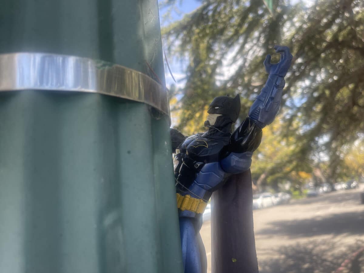 Alameda Post - A batman action figure clings to a light post.