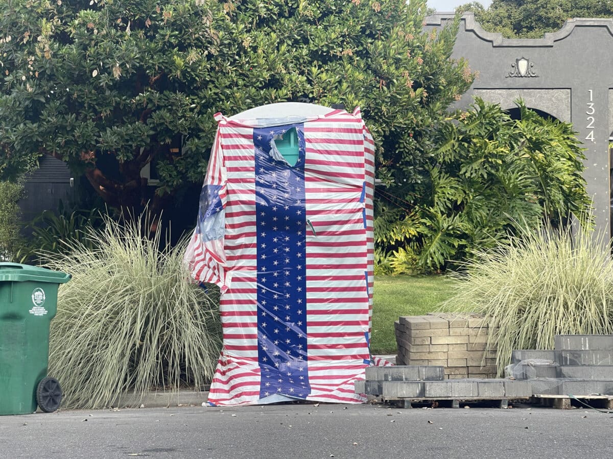 Alameda Post - A red white and blue draped portable potty.