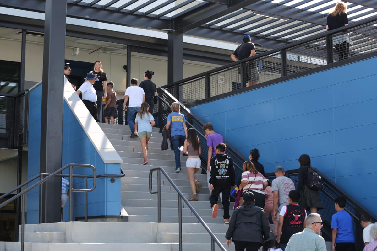 Alameda Post - A crowd of people walk up the steps at the new Wood Middle School building. 