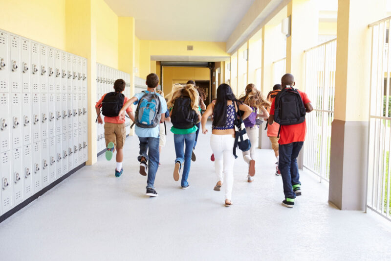 Alameda Post - a group of children run down a school corridor