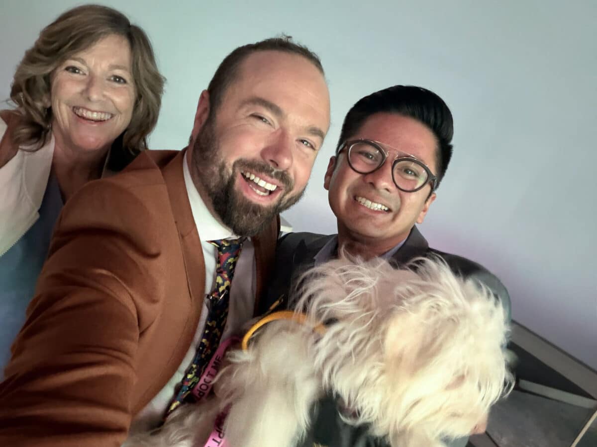Alameda Post - Two men and one woman smile in a selfie with a small dog.